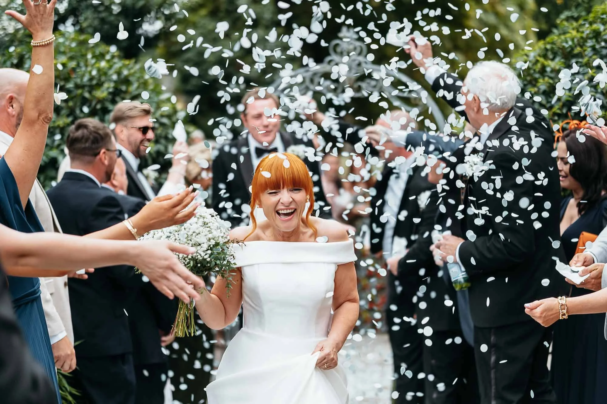 Guests throwing confetti over the couple outside The Croft Hotel on an autumn afternoon