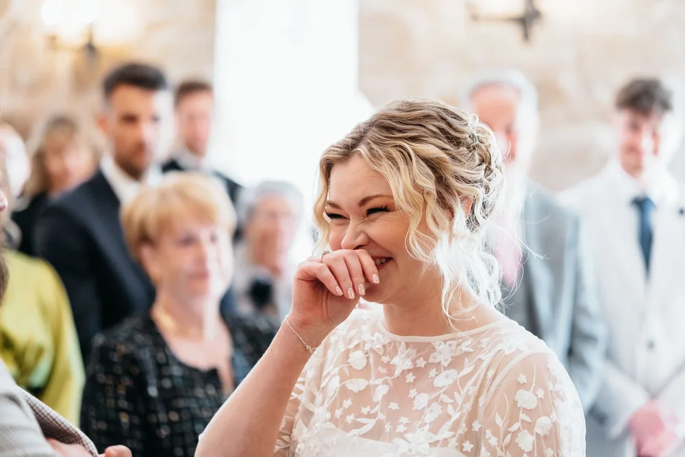 Bride laughing during her wedding ceremony at Danby Castle