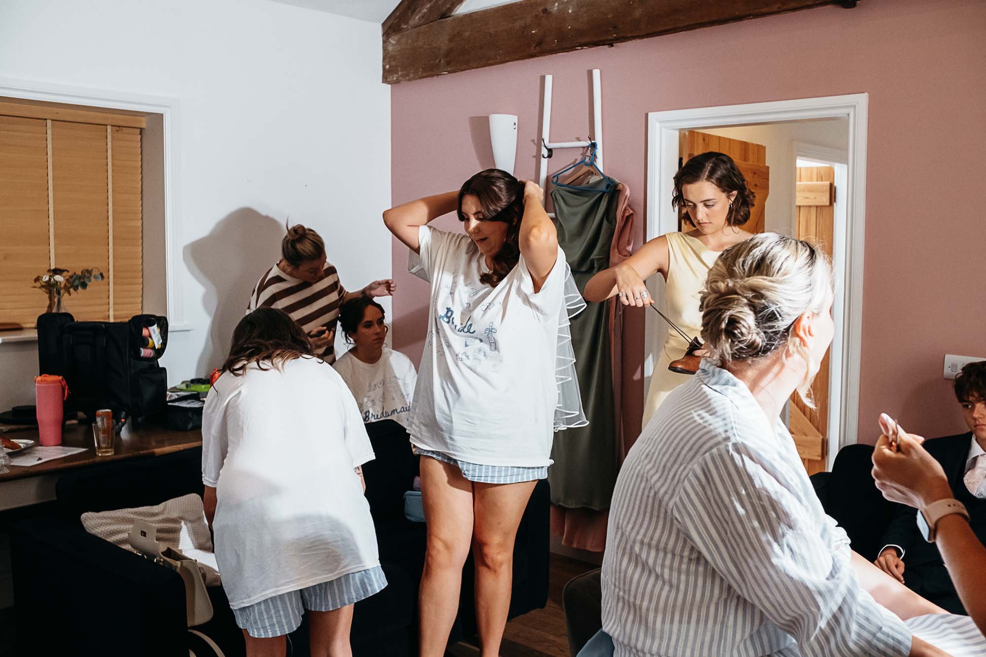 Bridesmaids in white robes getting ready together on the wedding morning