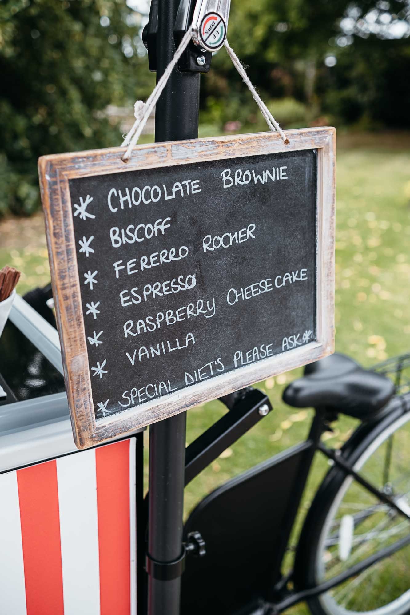 A chalkboard ice cream menu propped by the ice cream bike outside Howard Court