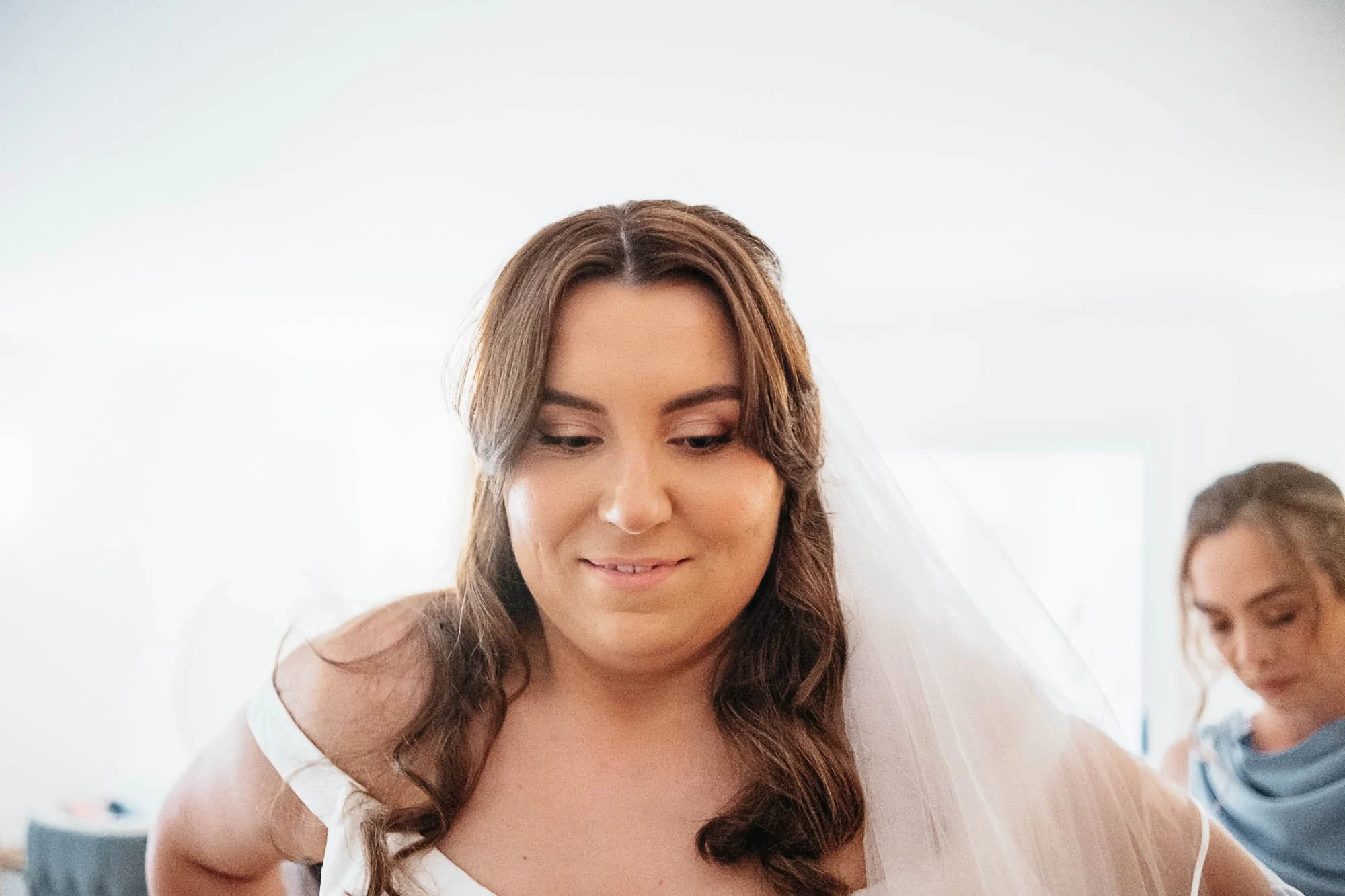 Aimee smiling as her veil is set in place