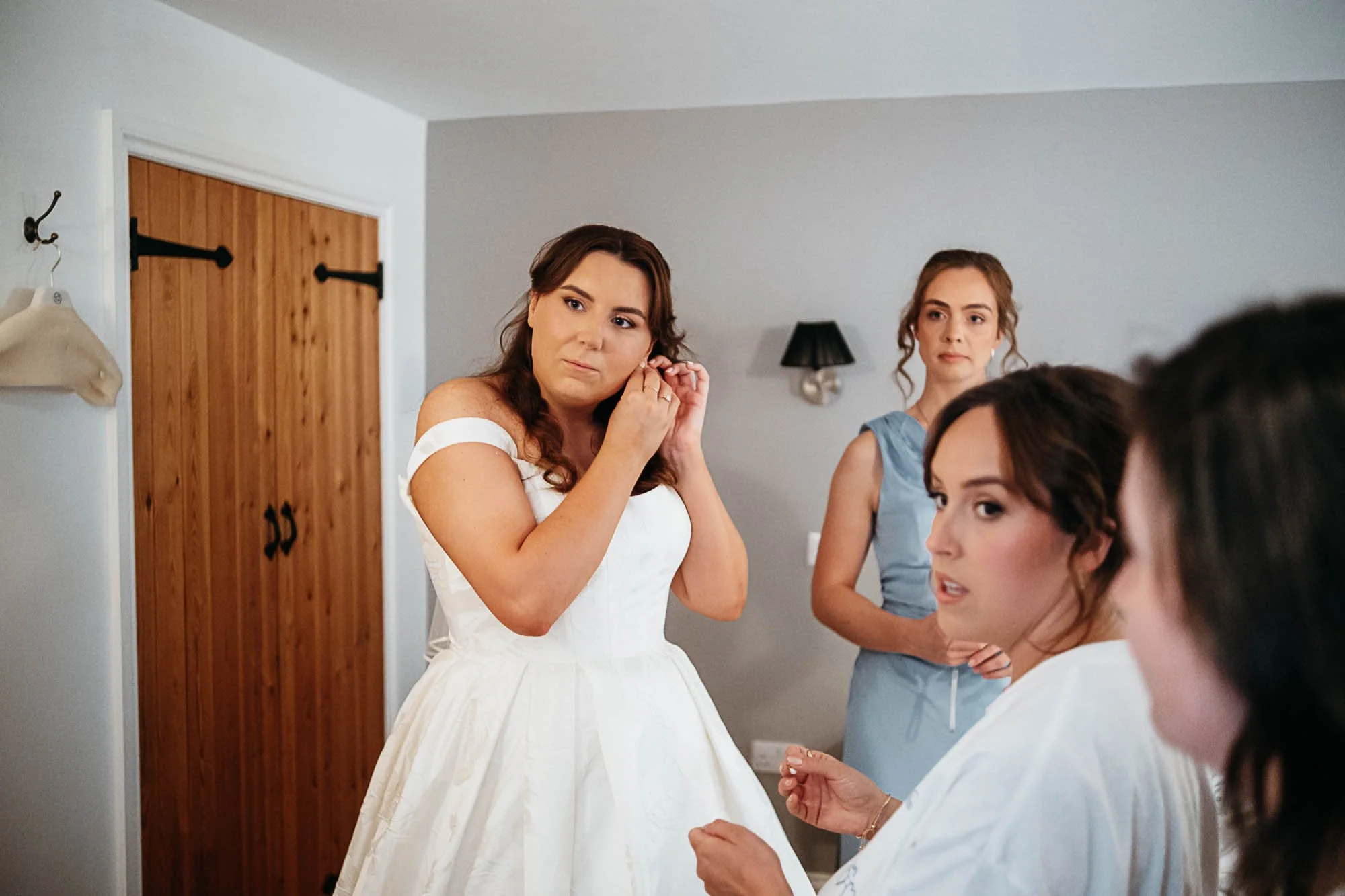 Aimee sitting with her bridesmaids, all smiling, just before the ceremony