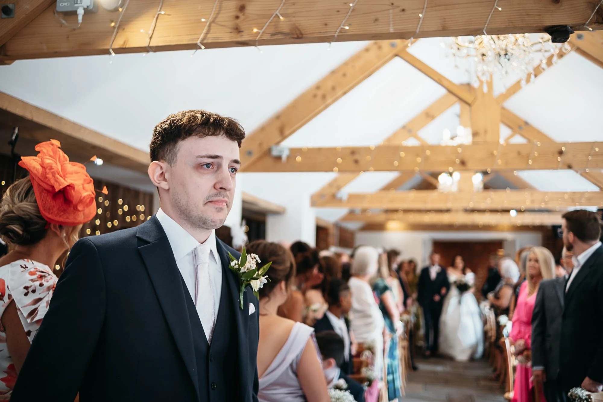 Dan standing at the front of the barn as guests gather under the beams