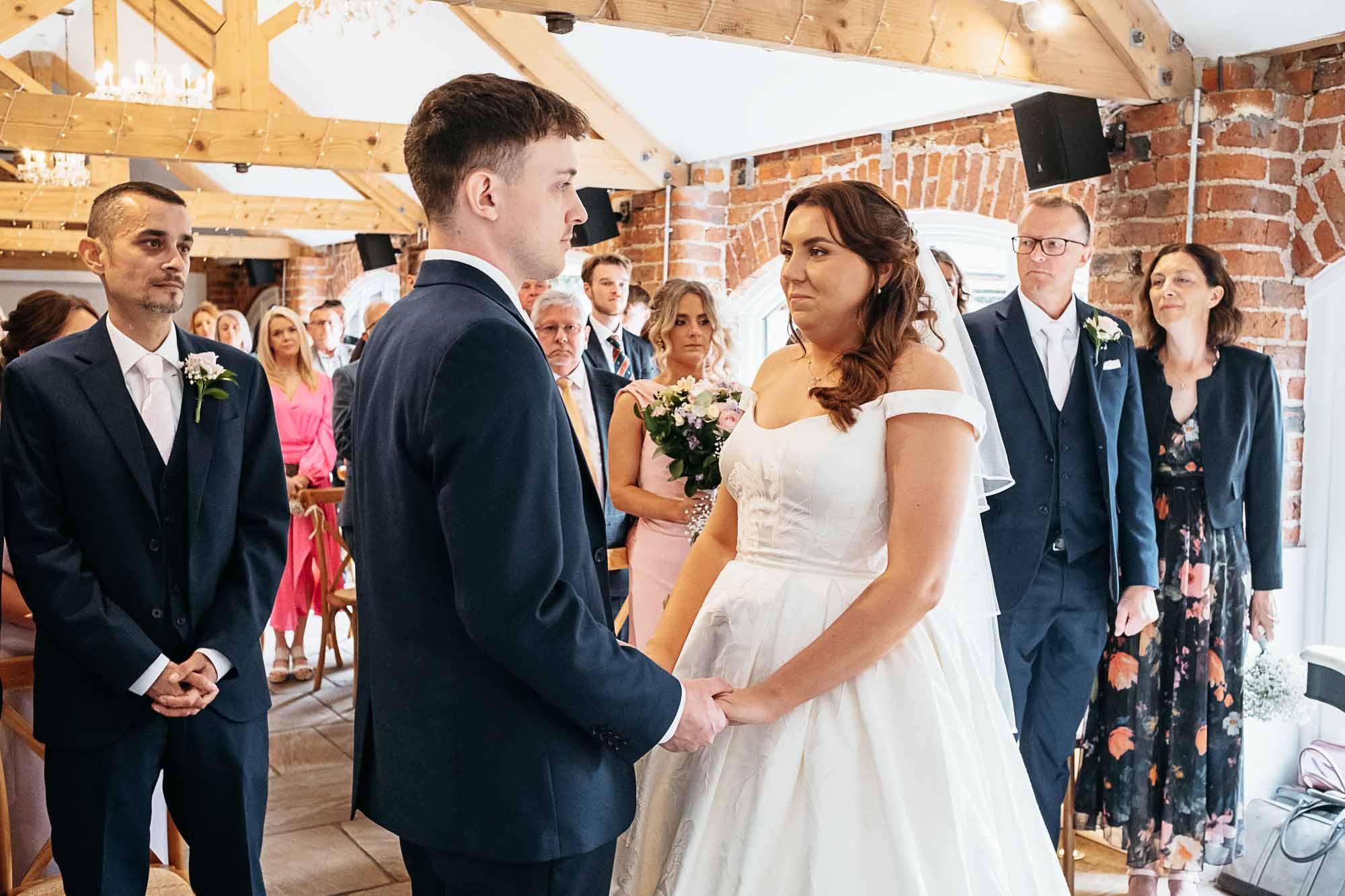 Aimee and Dan exchanging vows with their families watching