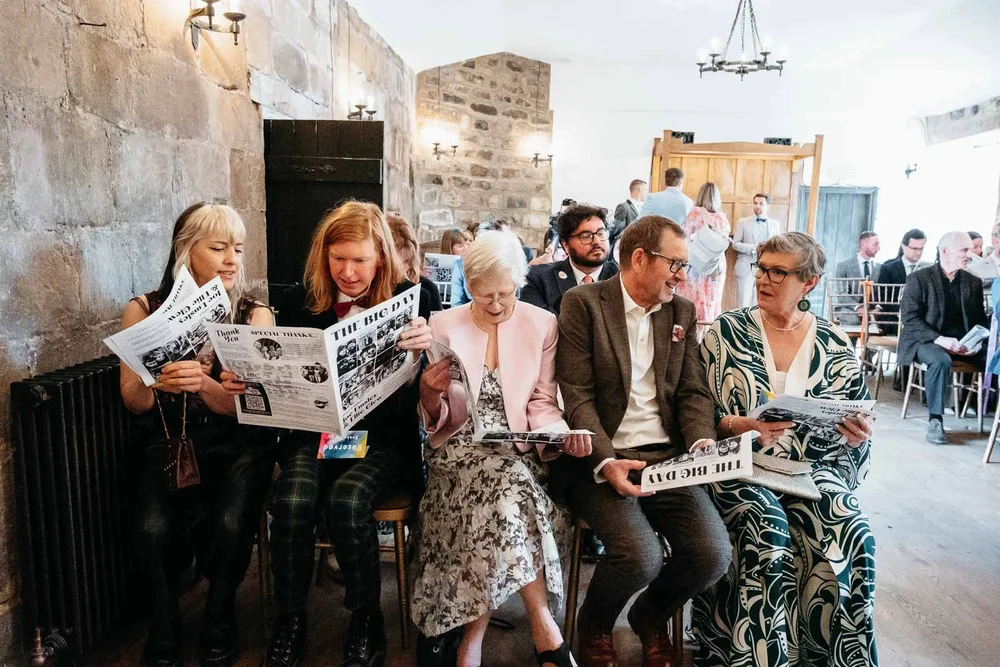 Wedding guests reading a newspaper before a ceremony at Danby Castle