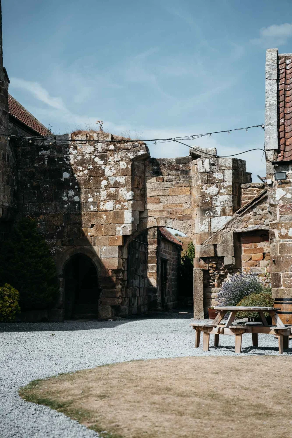 Historic stone archway and ruins at Danby Castle with festoon lights