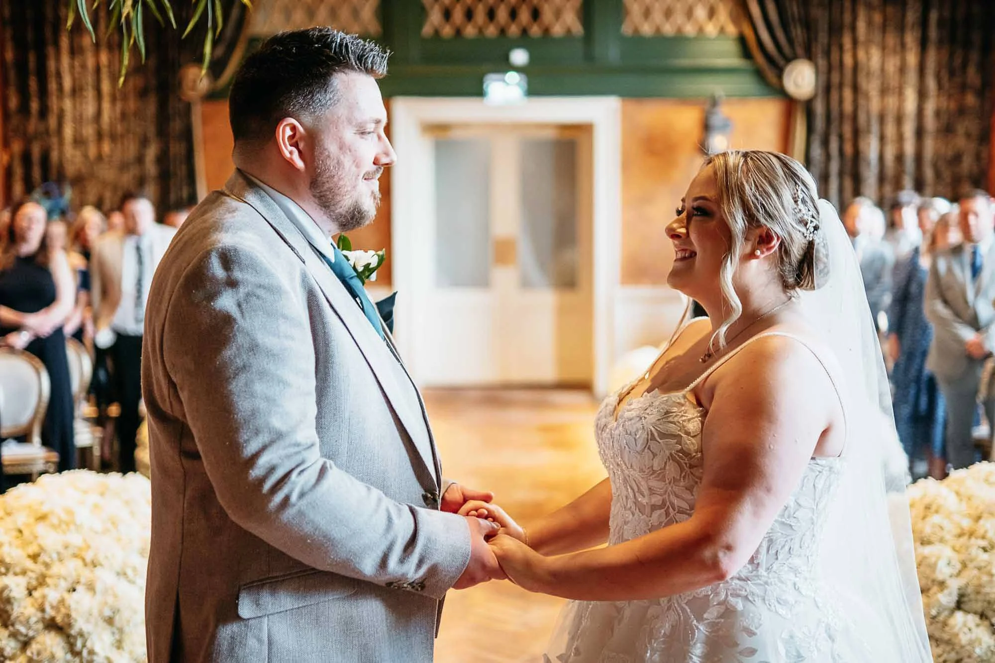 Bride and groom holding hands during their ceremony in the Secret Garden Chapel at The Croft Hotel