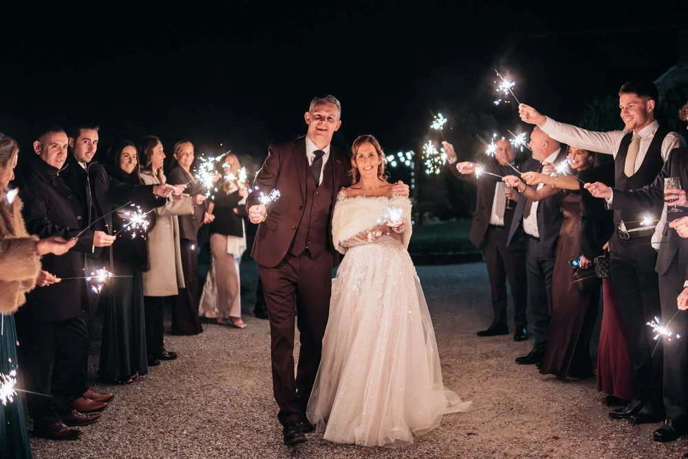 Bride and groom surrounded by sparklers during a winter wedding at Danby Castle