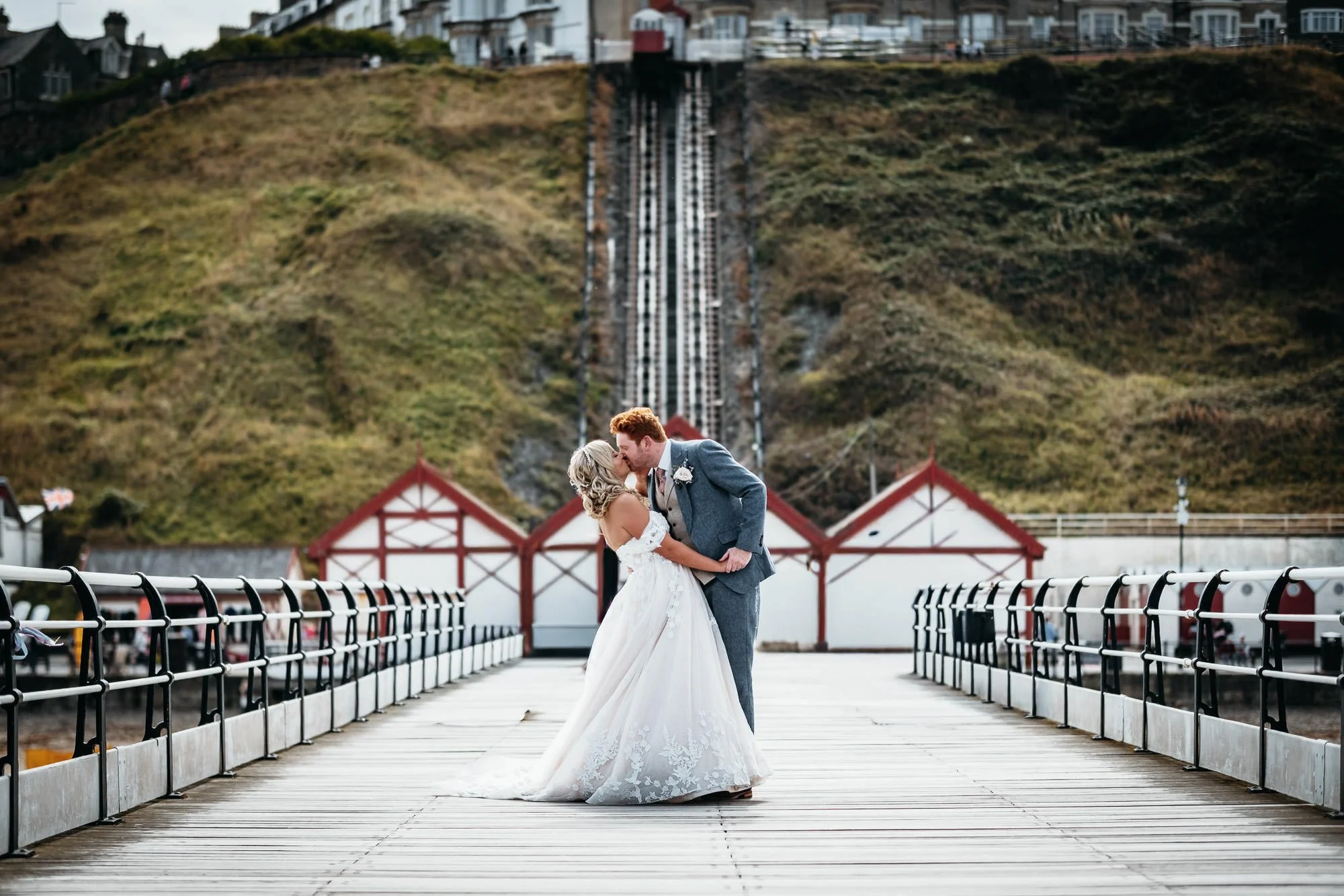 Bride and Groom kiss on a pier in saltburn