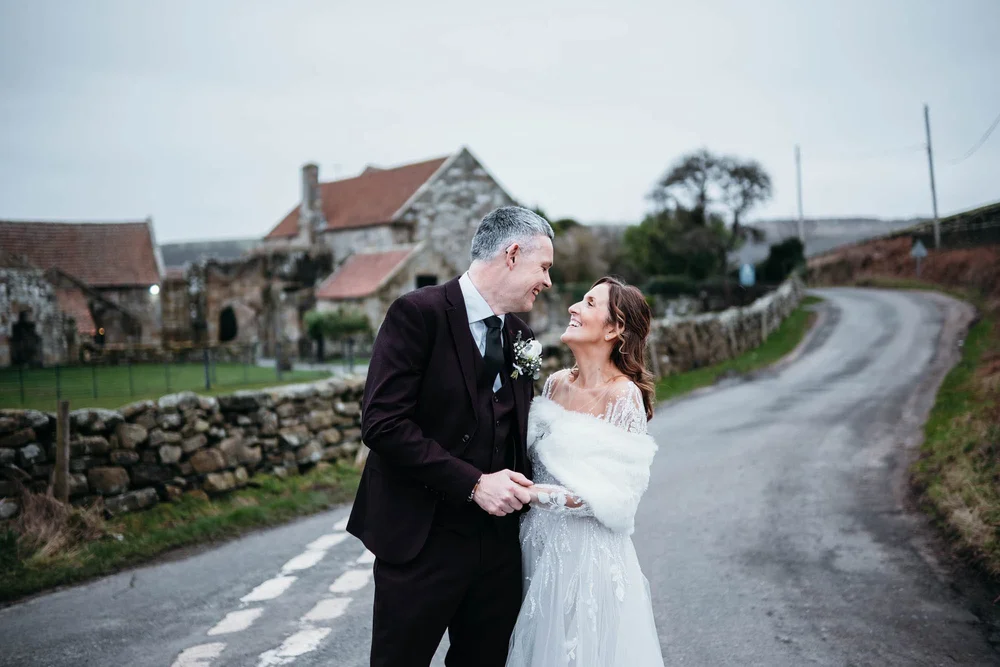 Bride and groom photographed on the lane near Danby Castle during a winter wedding