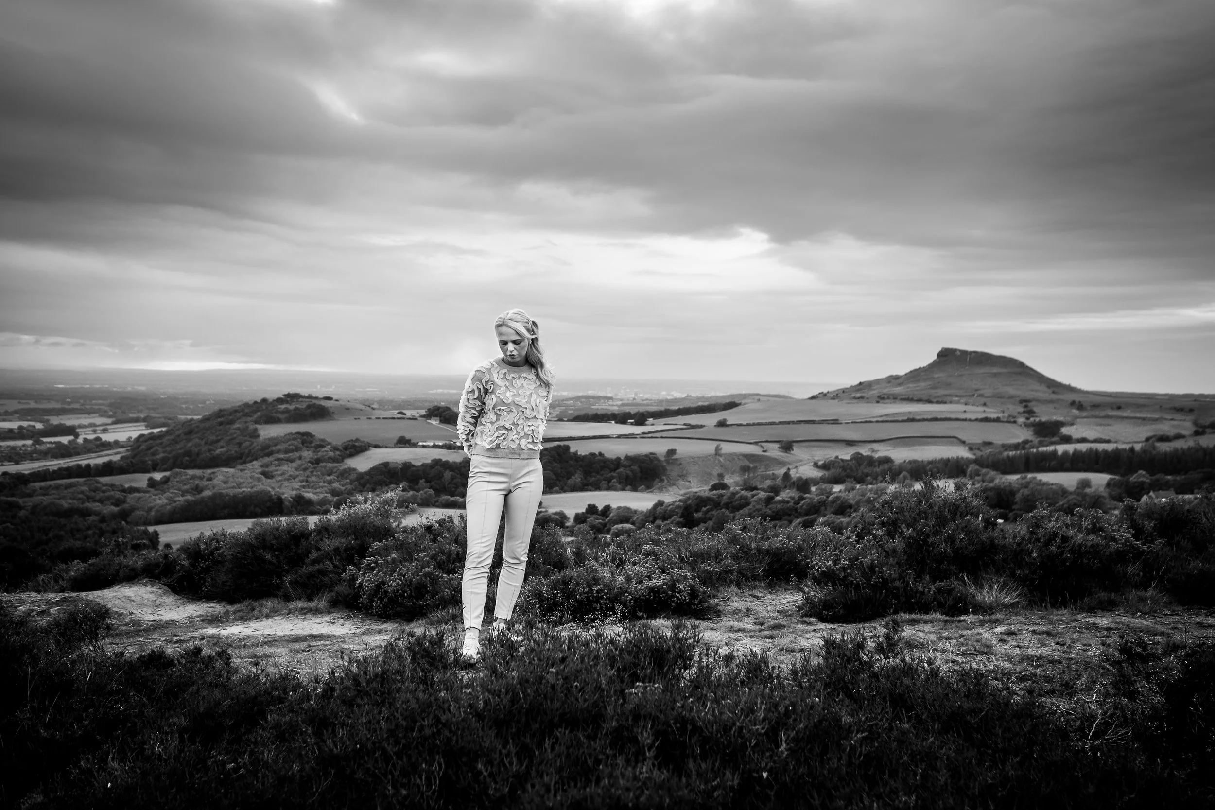 Sophie stands on top of gribdale rock with roseberry topping in the back ground