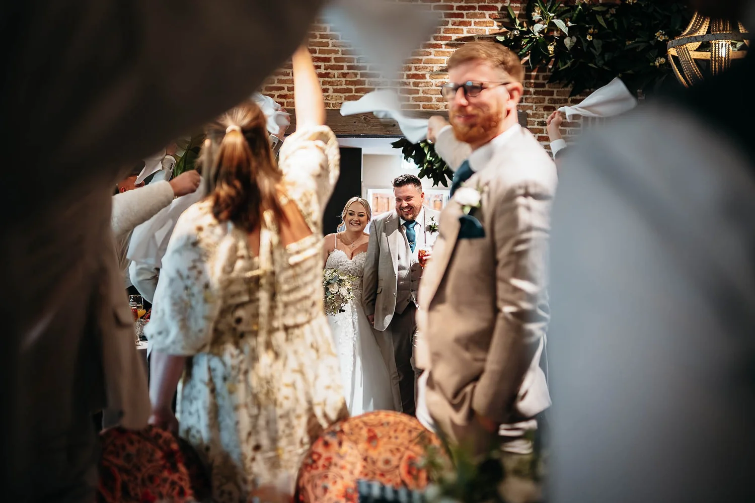 Guests waving white napkins as a bride and groom enter the Garden Suite at The Croft Hotel