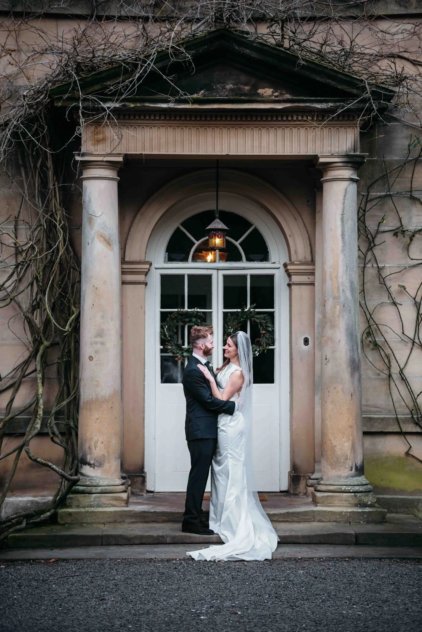 Couple under the stone portico of the Georgian Main House at Middleton Lodge, Richmond
