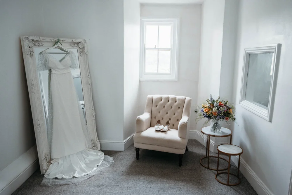 Wedding dress hanging in the getting-ready room at Danby Castle