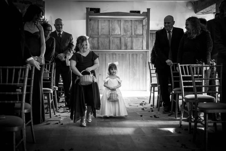 Two flower girls walking down the aisle at a Danby Castle wedding