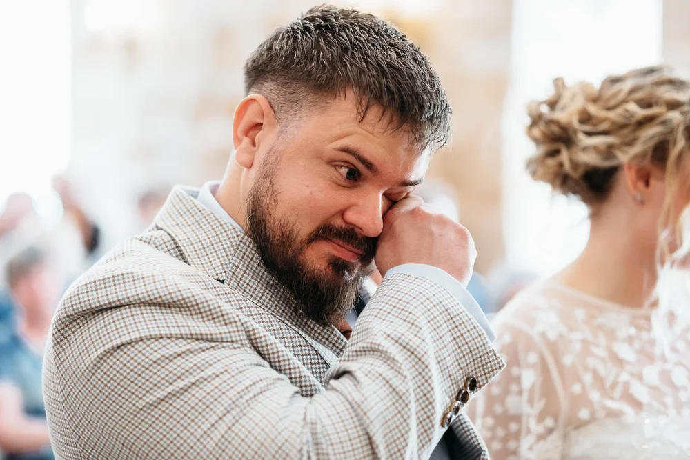 Groom wiping his eye during an emotional wedding ceremony at Danby Castle