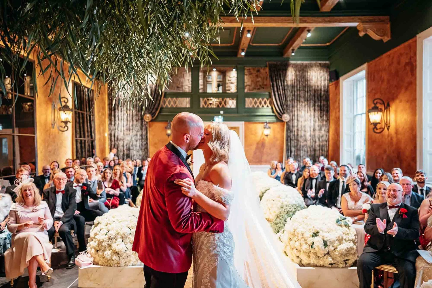 Bride and groom's first kiss in the warmly lit Secret Garden Chapel at The Croft Hotel