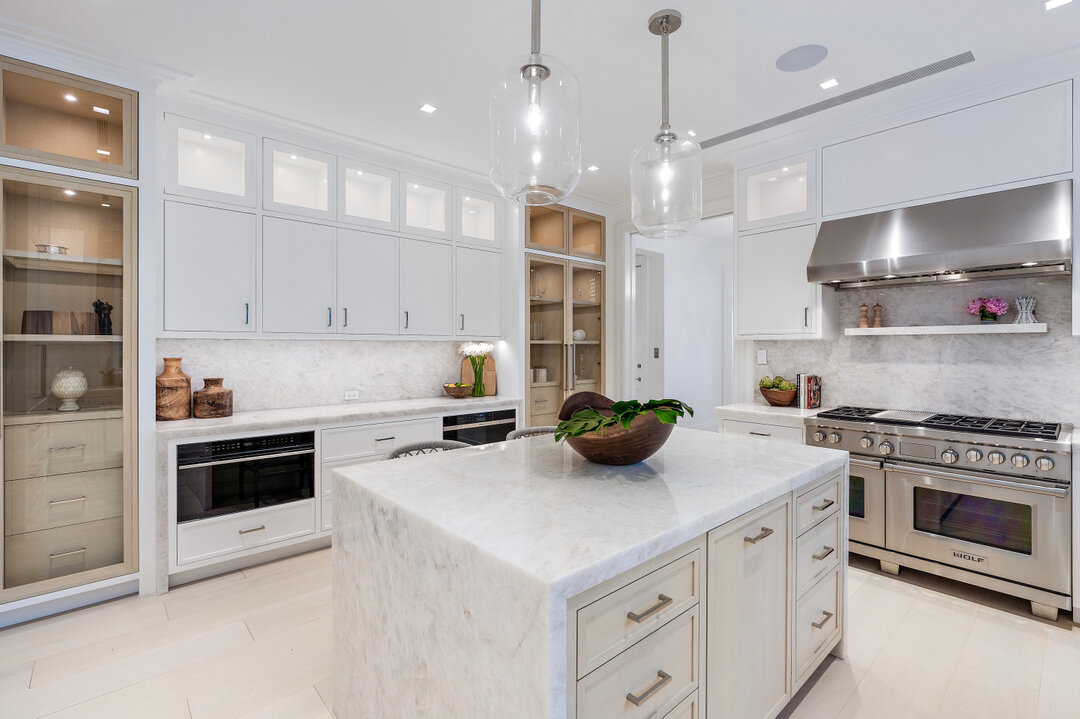 Bright white kitchen draped with beautiful slabs of Cristallo.