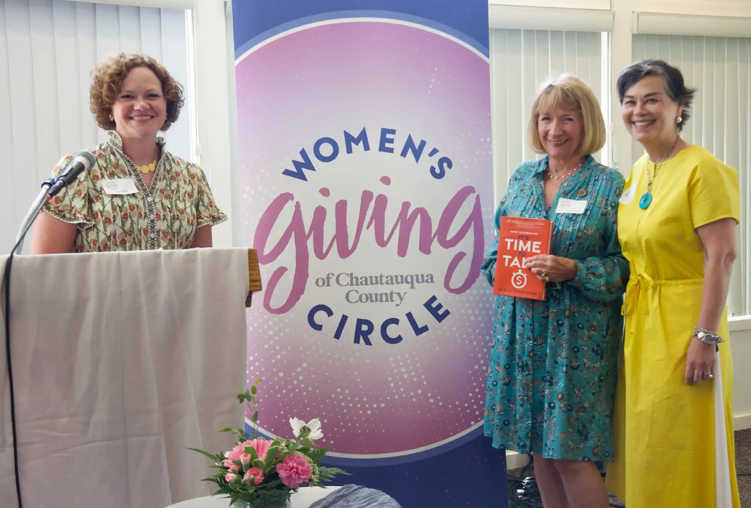 Three women at the podium during the Women's Giving Circle 2026 Annual Meeting