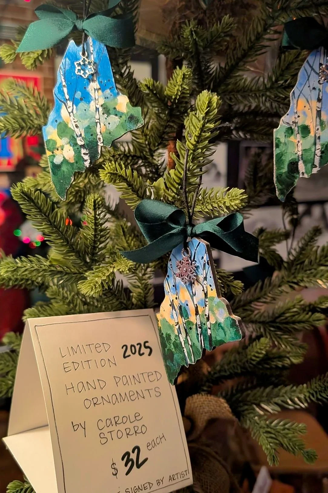 Carole Storro's 2025 ornaments are perfect for a family member or friend that has ties to Maine. These hand painted ornaments are sure to sell out at only $32.00.
