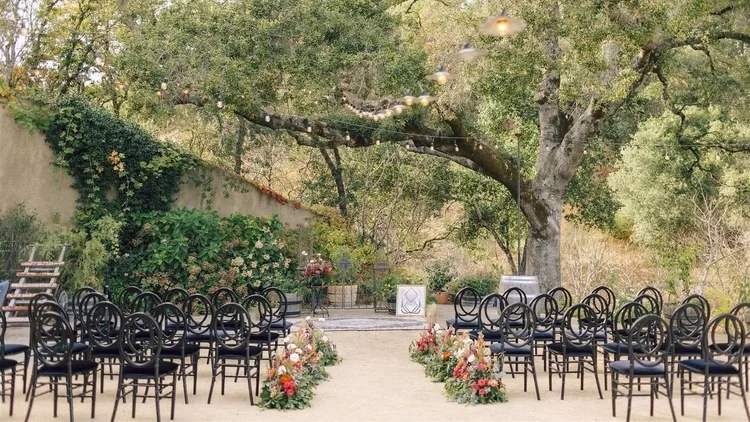 Ceremony aisle beneath an oak tree at a curated wine country wedding venue