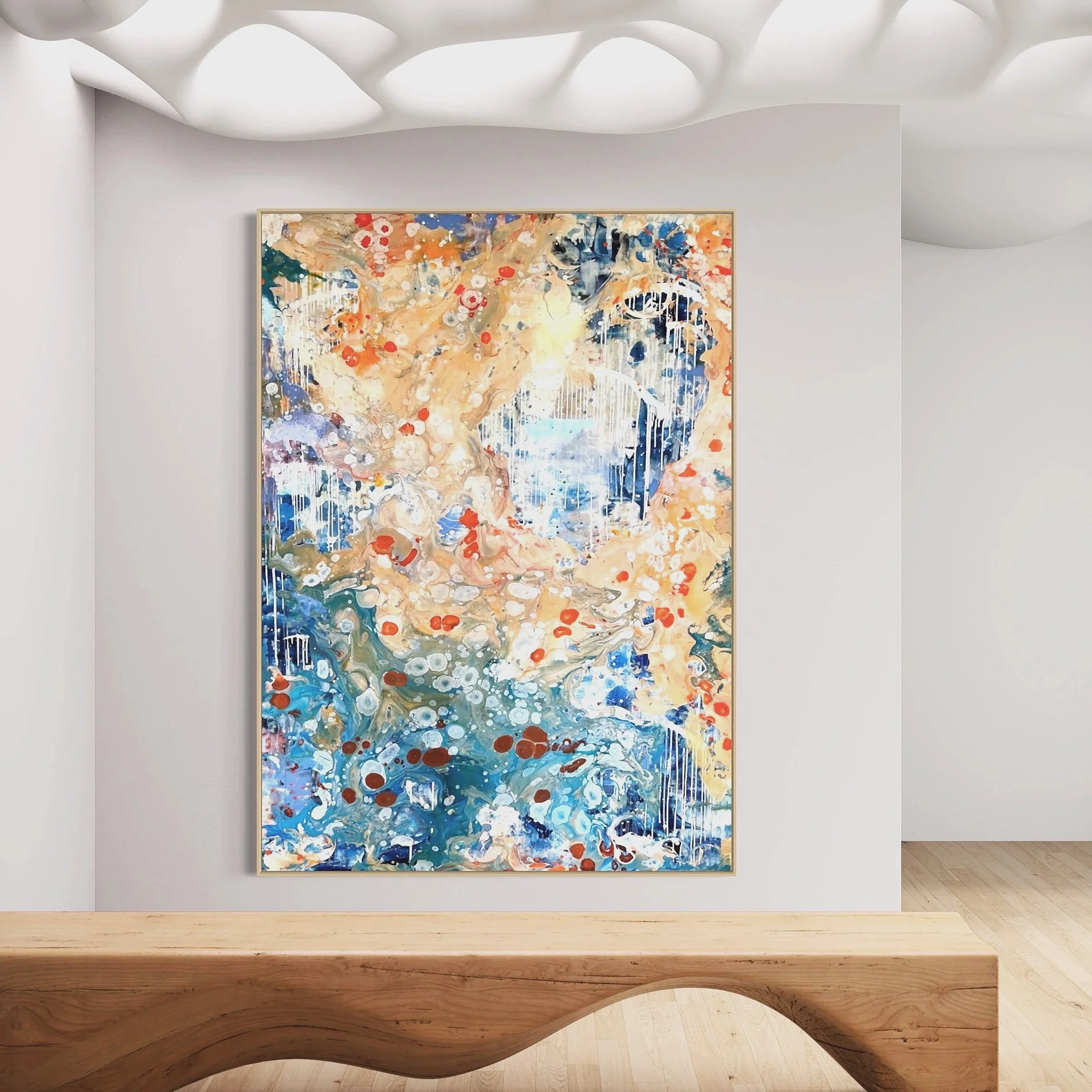 A colorful abstract expressionist painting with blue, orange, red, beige, and white tones, displayed on a white gallery wall with a soft ceiling light overhead and a curved wooden bench in the foreground.