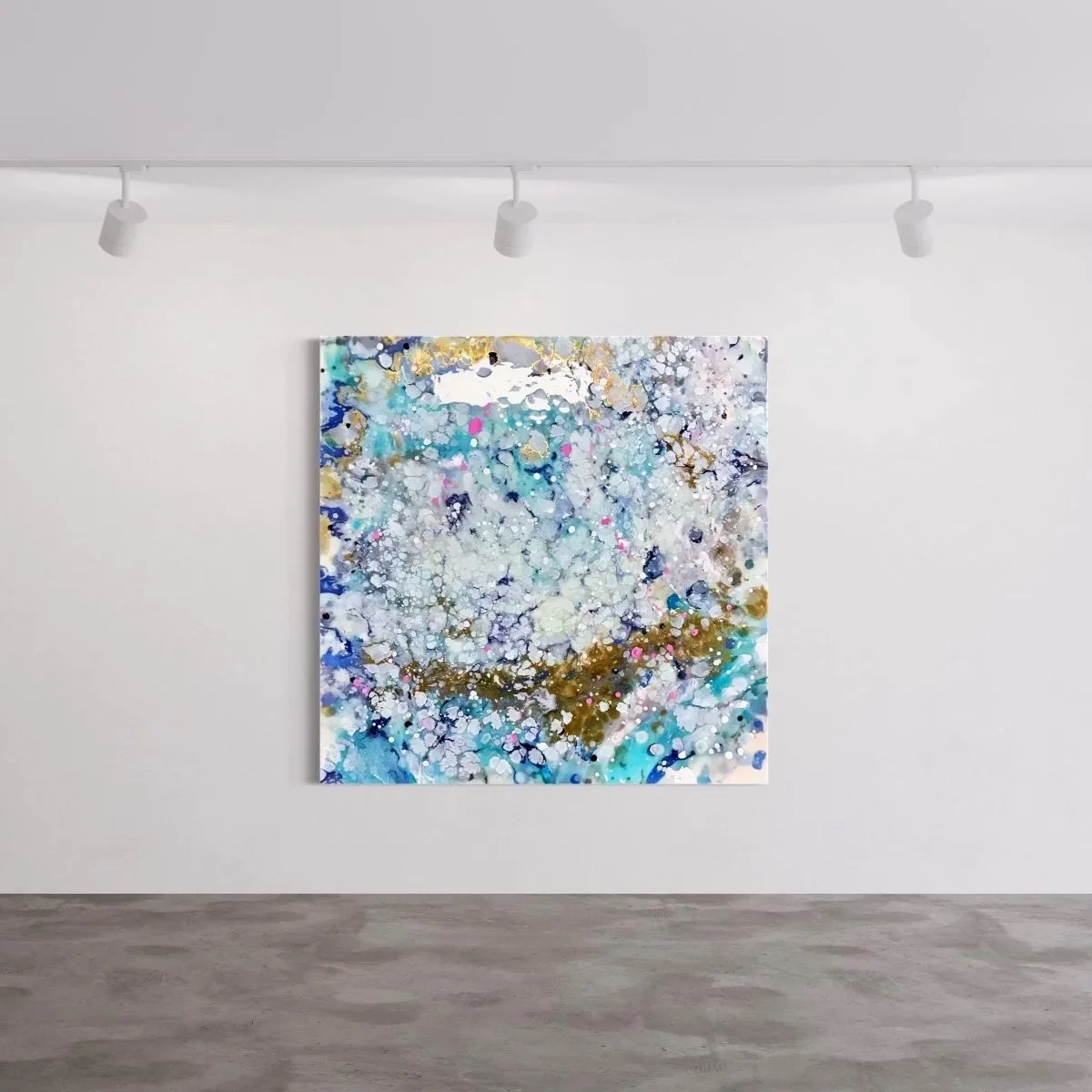 Abstract modern art painting with splashes of blue, white, gold, and pink on a white gallery wall.