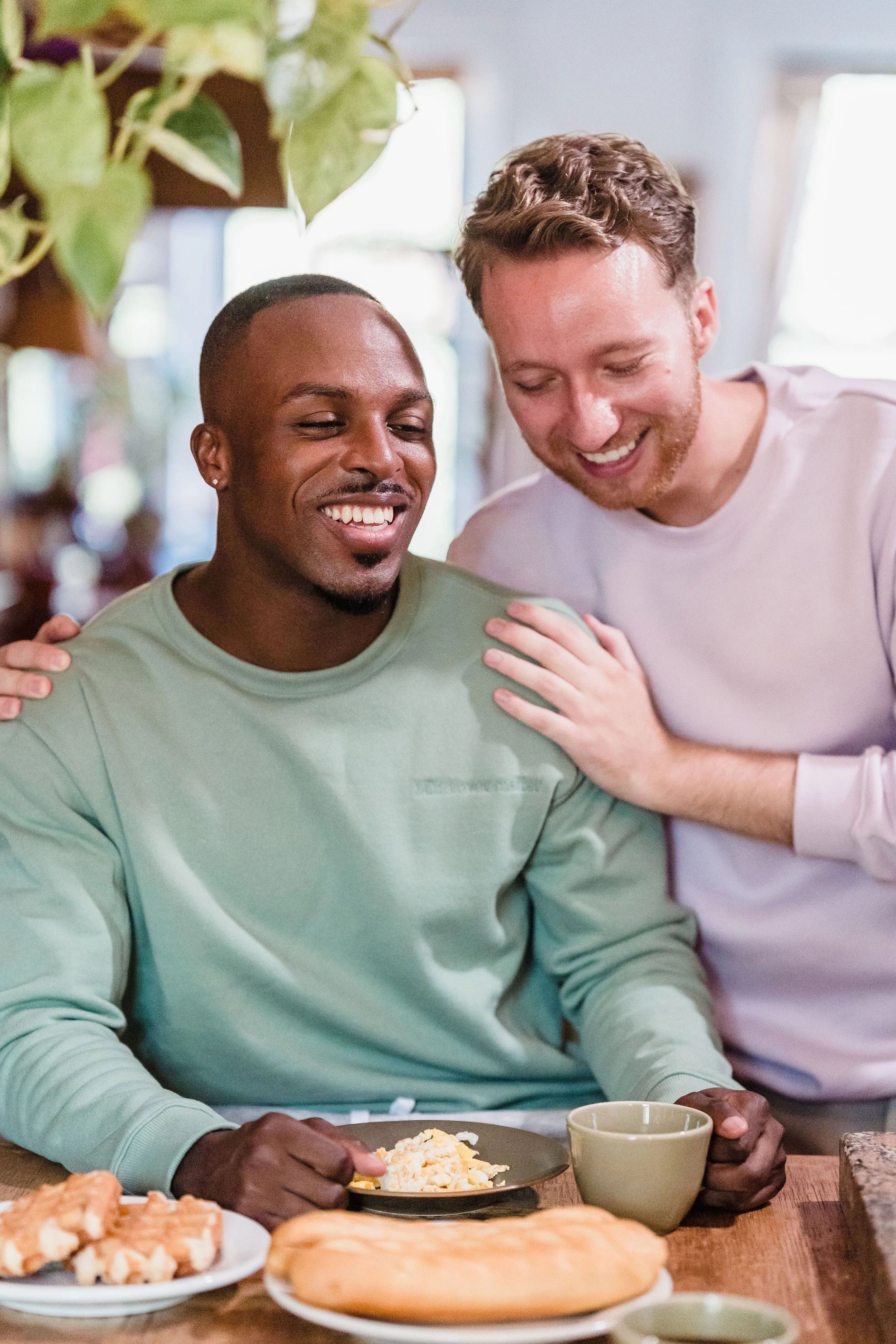 Two fully clothed men sharing a comfortable, platonic embrace in a safe and welcoming environment