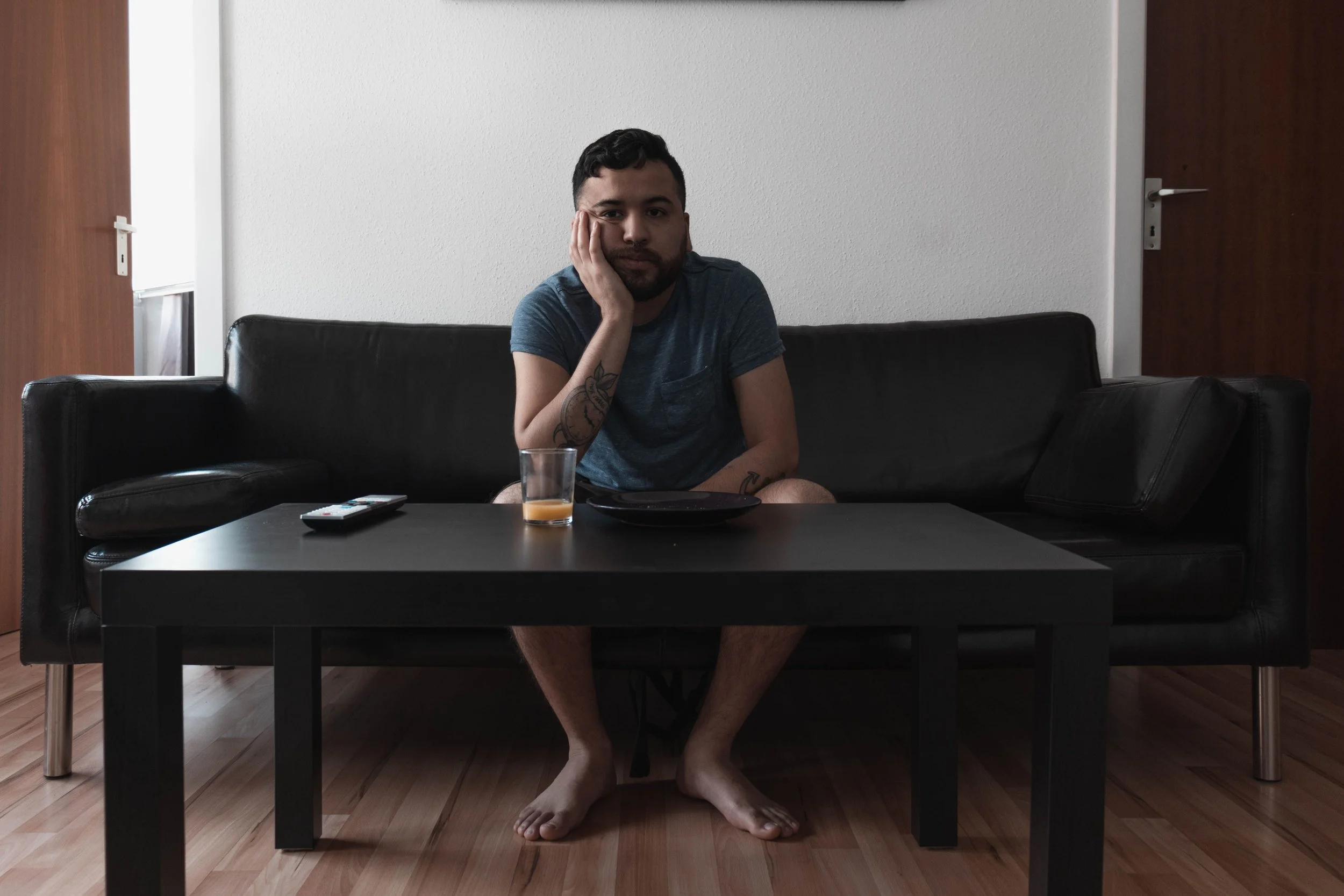 Man sitting alone on a couch in a quiet moment of reflection