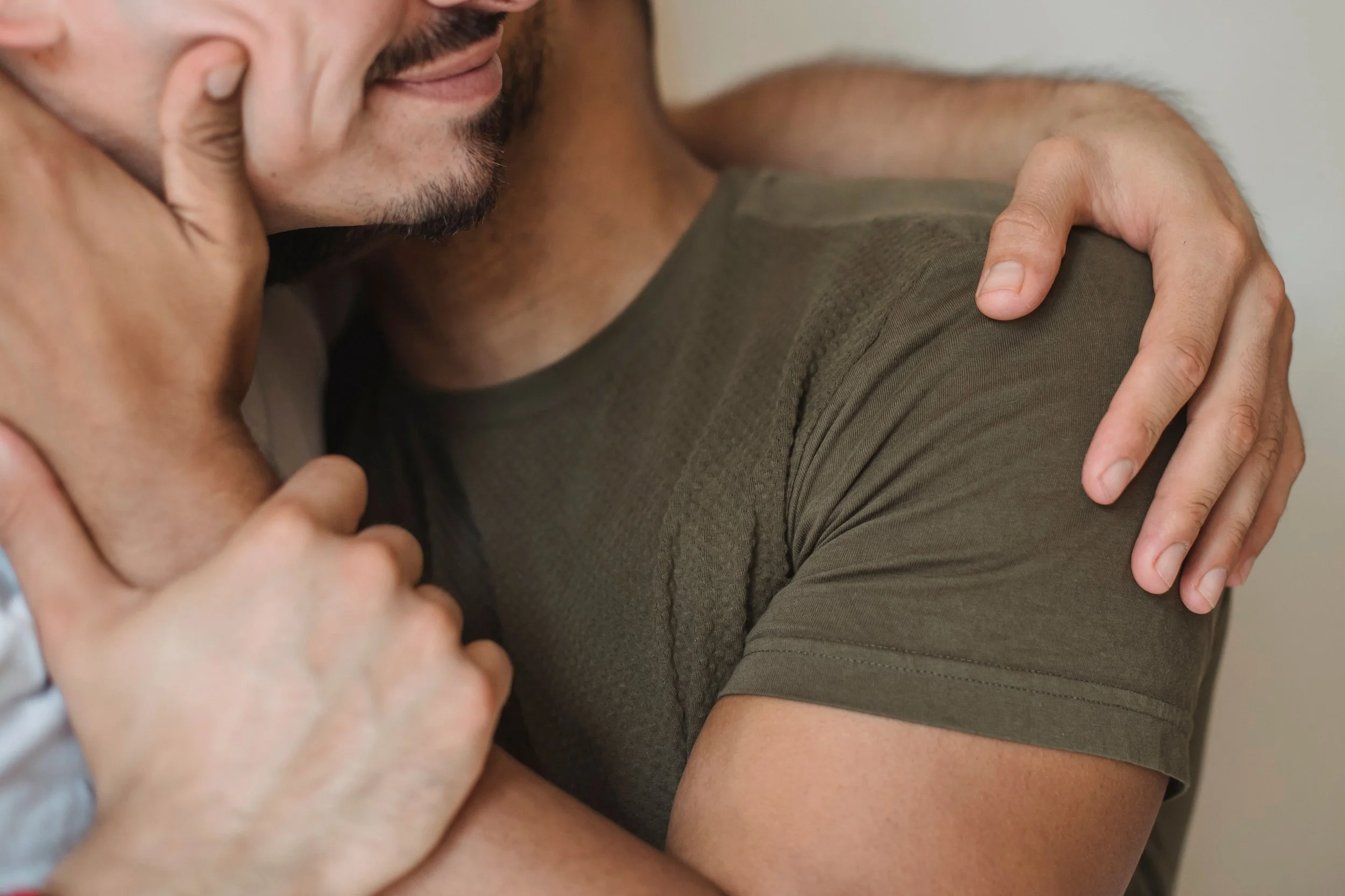 Close-up of two men's hands during a gentle, supportive touch