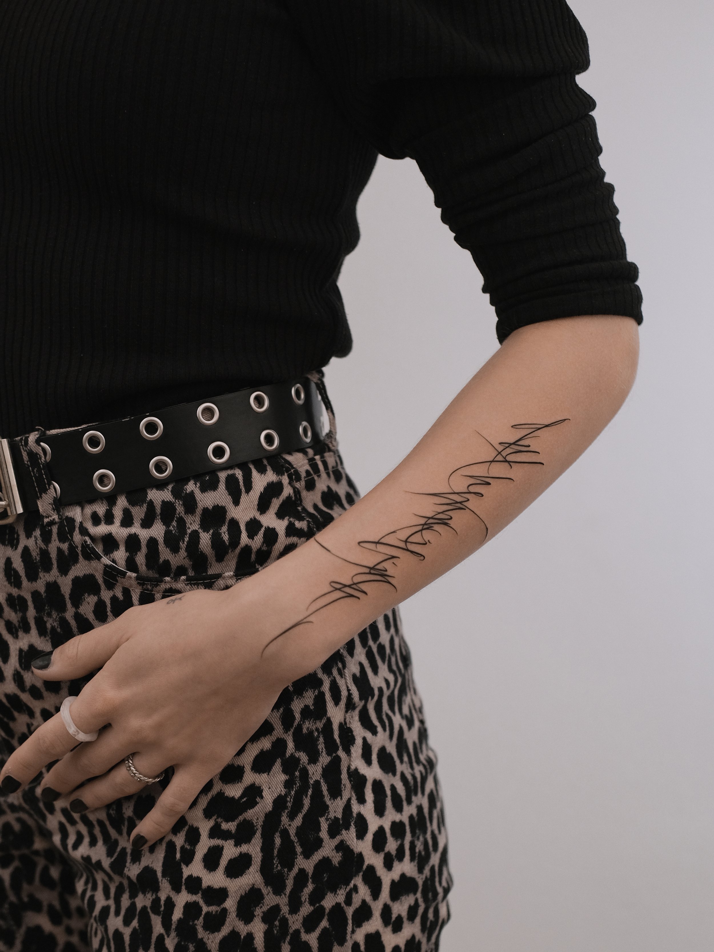 Close-up of a person's arm showing a tattoo with the name 'Anahi' written in cursive, against a light background.