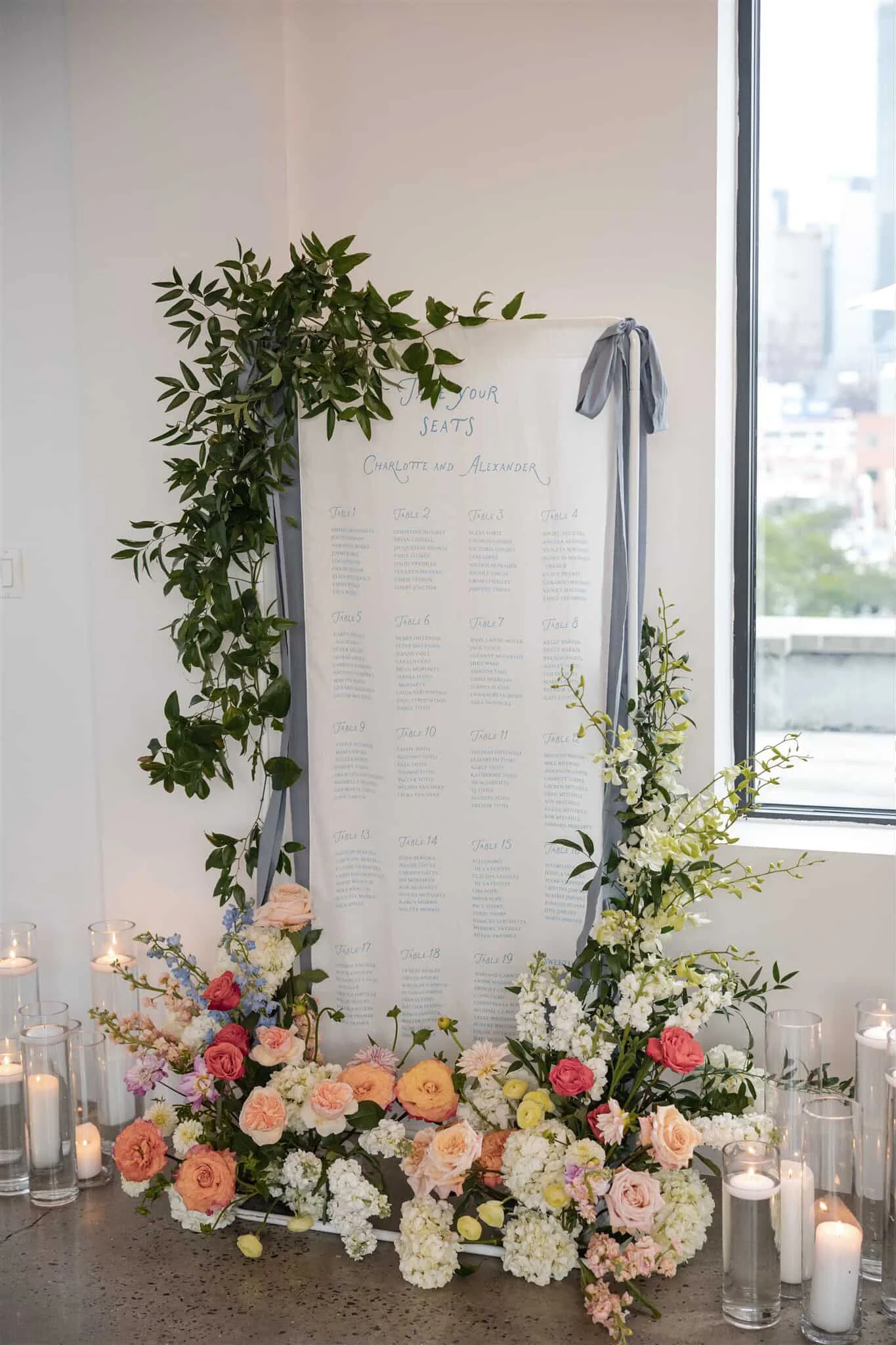 Wedding seating chart with floral decoration and candles.