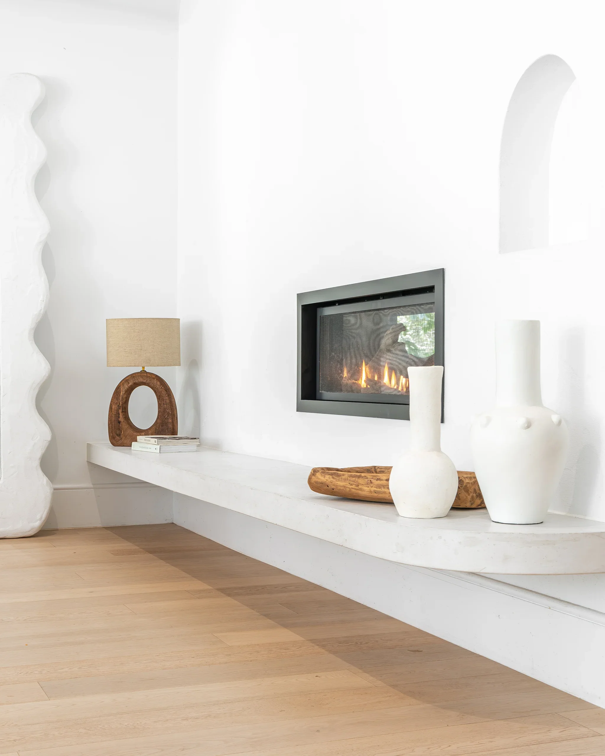 uniqwa-collections-modern-fireplace-styling-ceramic-vases-wood-accents-and_luma-table-lamp.webp