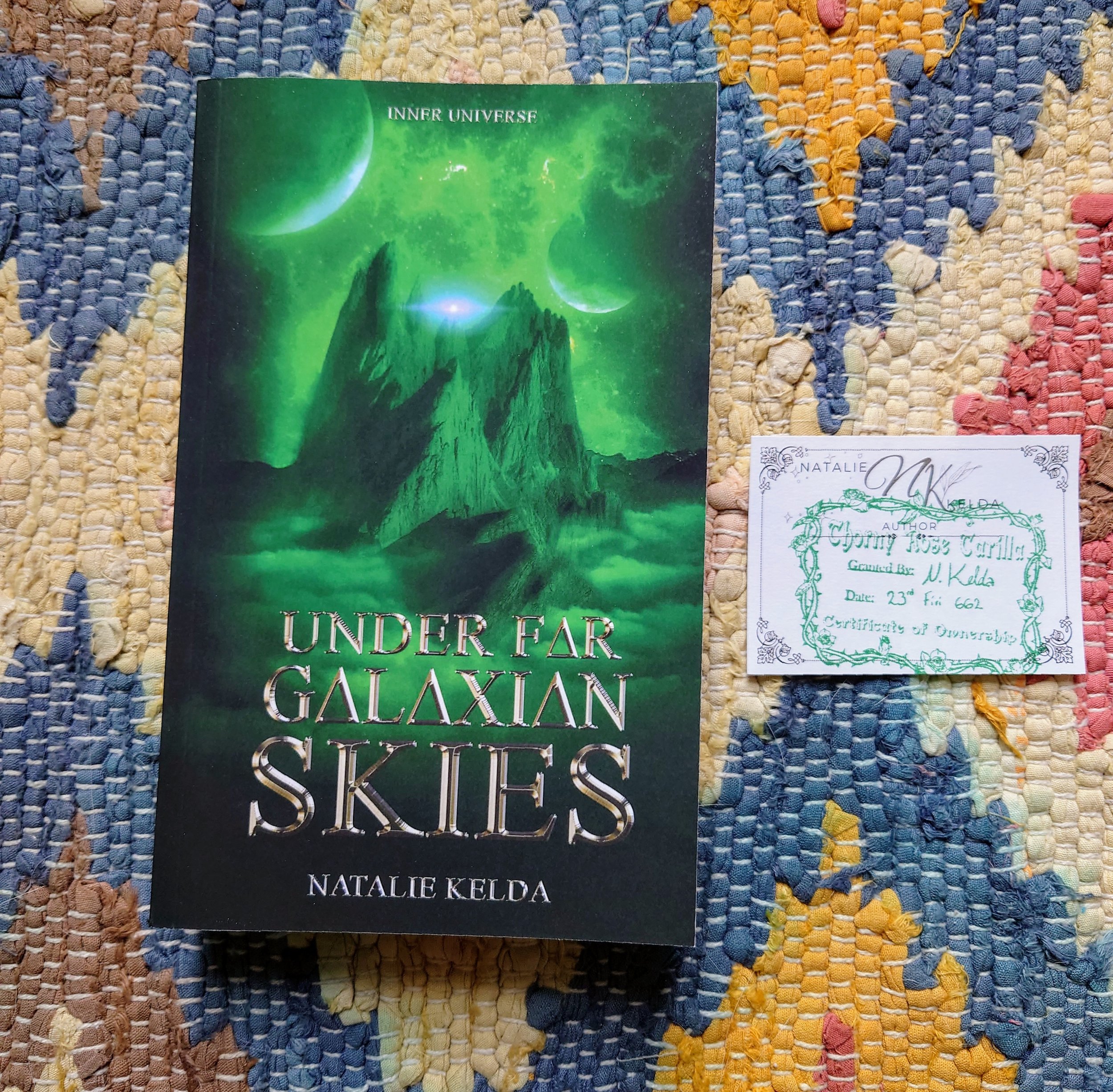 Under Far Galaxian Skies with a green stamped bookplated beside it.