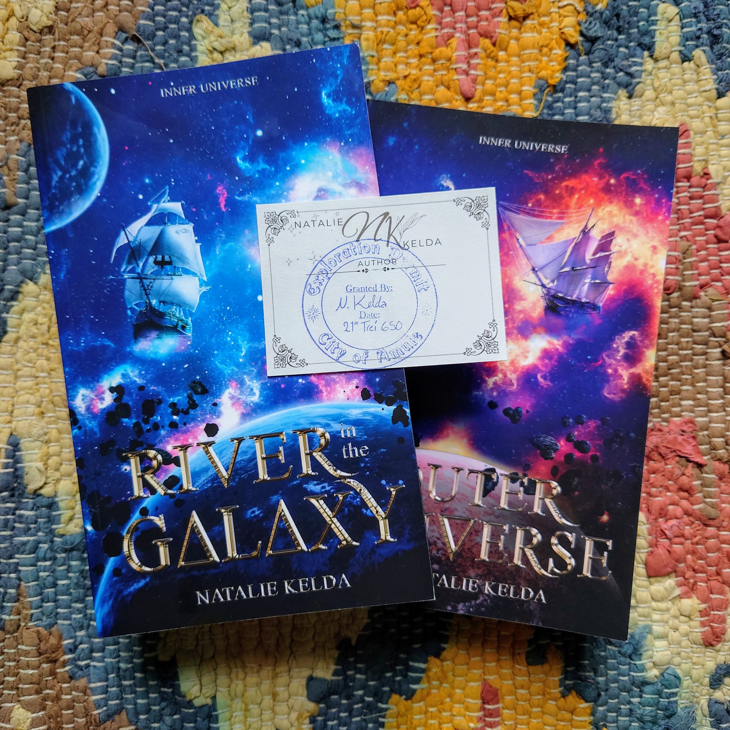 River in the Galaxy and Outer Universe on a colourful rug with a blue stamped bookplate on top of both books.
