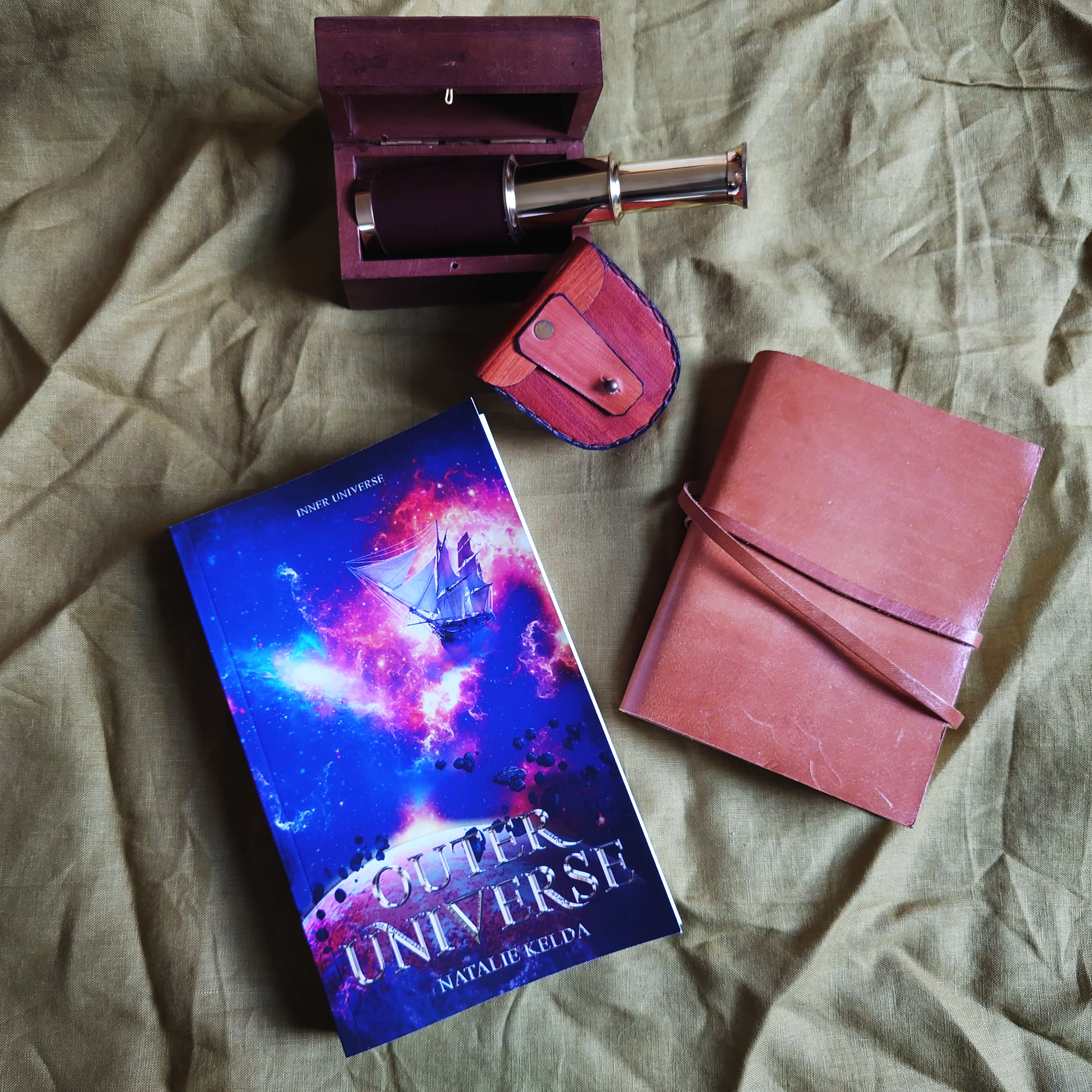Lifestyle of Outer Universe book with notebook and spyglass props.