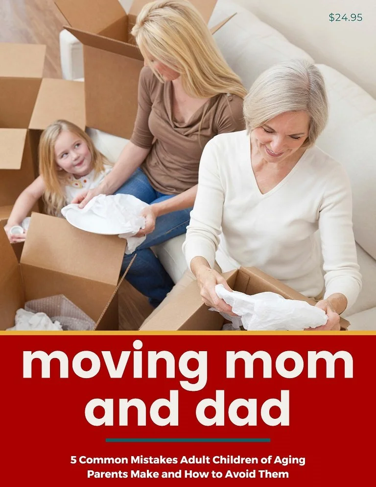Two women, one elderly and one middle-aged, are packing moving boxes while a young girl watches. The scene appears to be in a living room with moving boxes around.