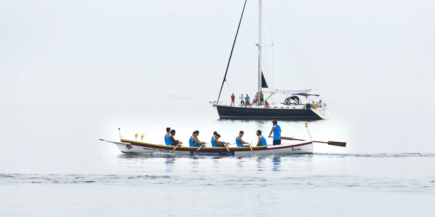 A rowing team moving together across calm water