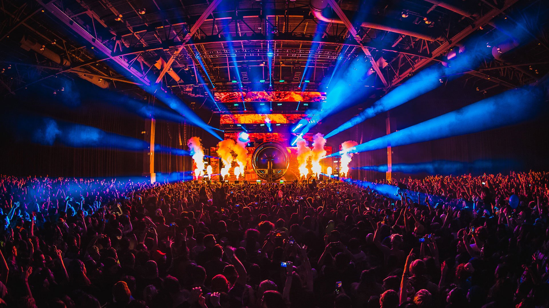 Subtronics Fractor Tour 2022 with BNE Productions' Audio Touring Package. View from the crowd facing the stage with blue strobe lights and pyrotechnics.