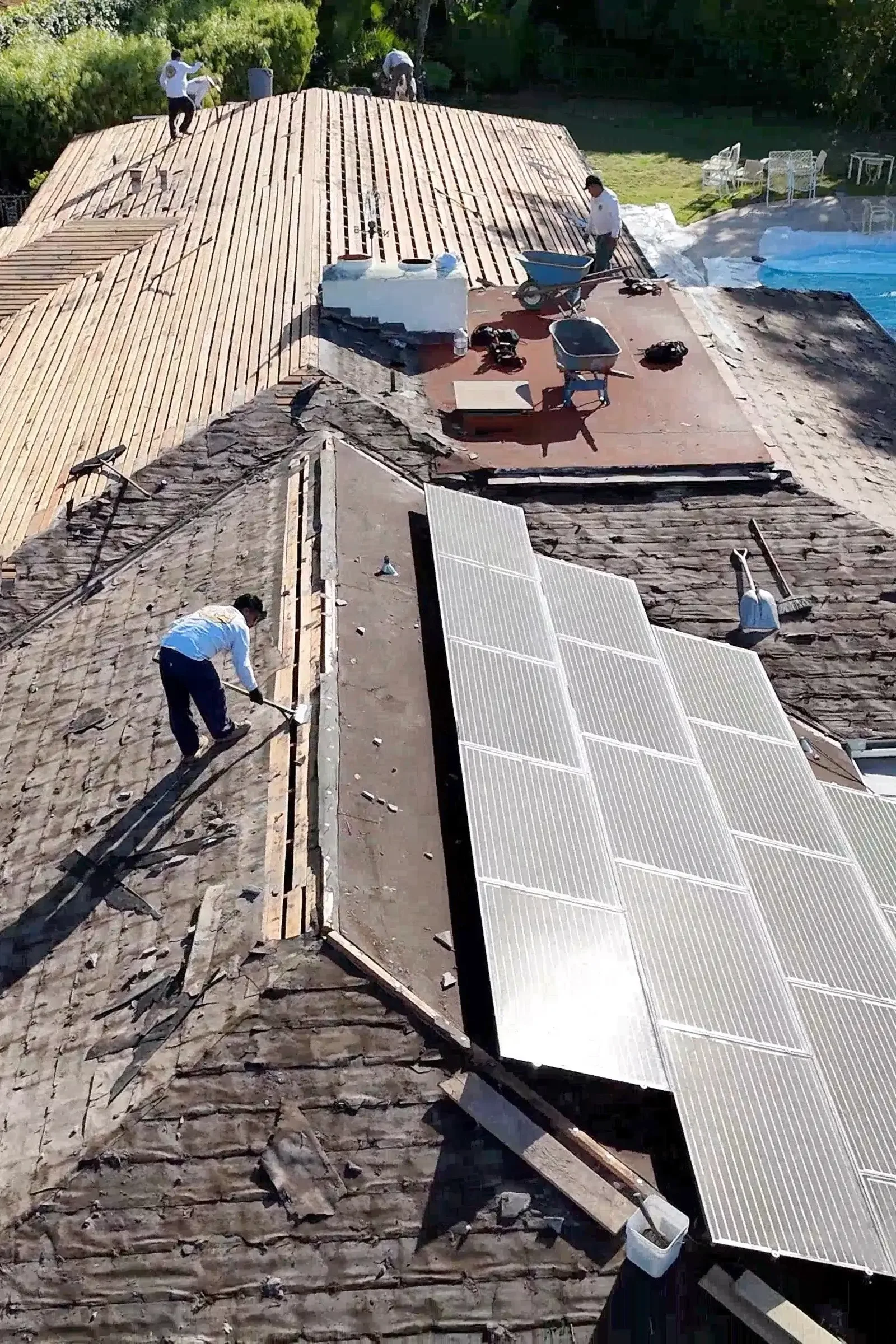 Residential roof replacement process in Santa Barbara with roofing crew removing old materials and preparing the roof deck.