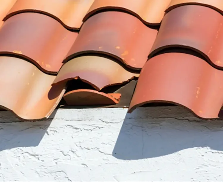 Expert tile roof repair in Carpinteria, CA, showing replacement of cracked Mediterranean clay tiles to prevent leaks.