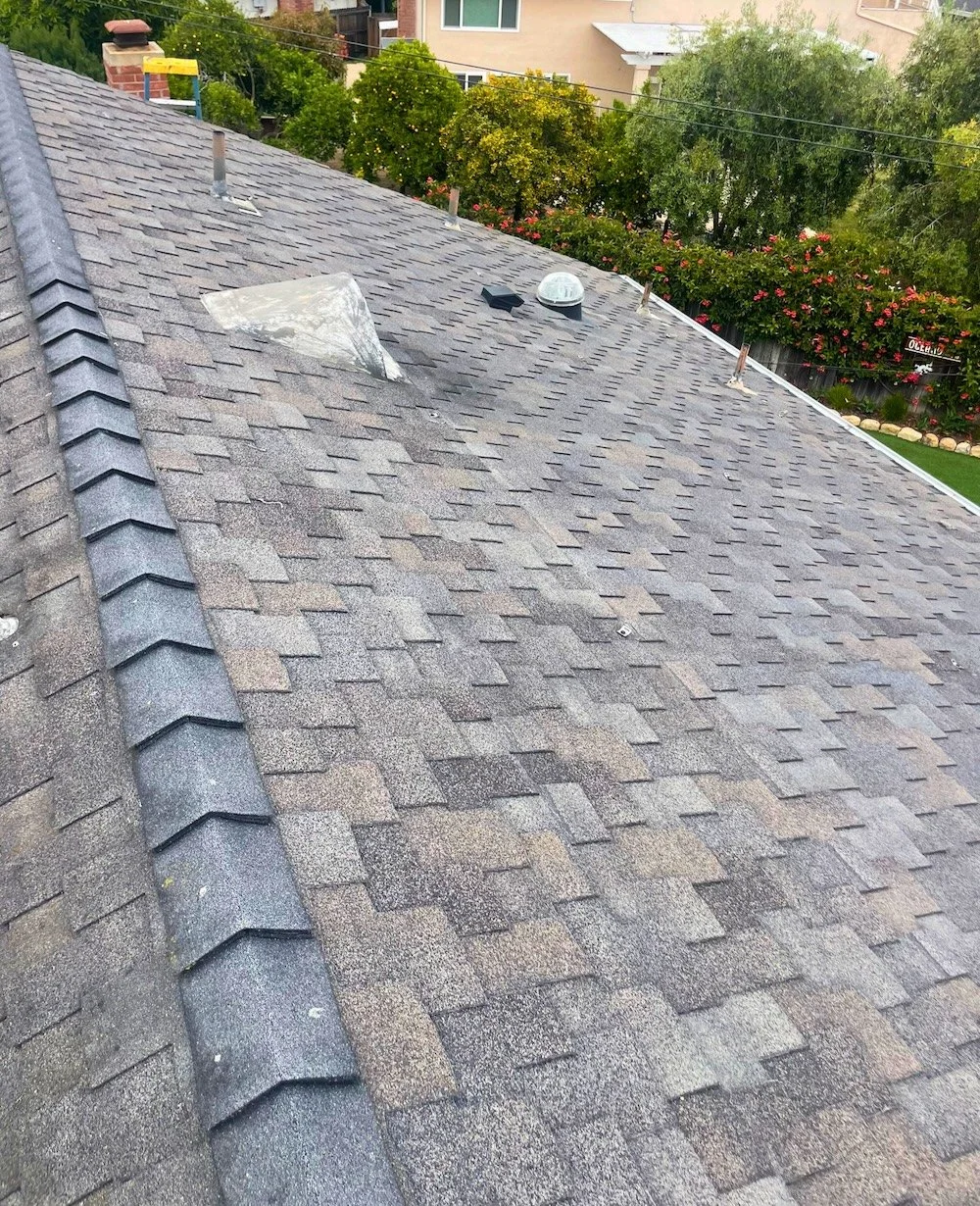 Aged asphalt shingle roof with discoloration and worn areas on a Santa Barbara home before replacement.