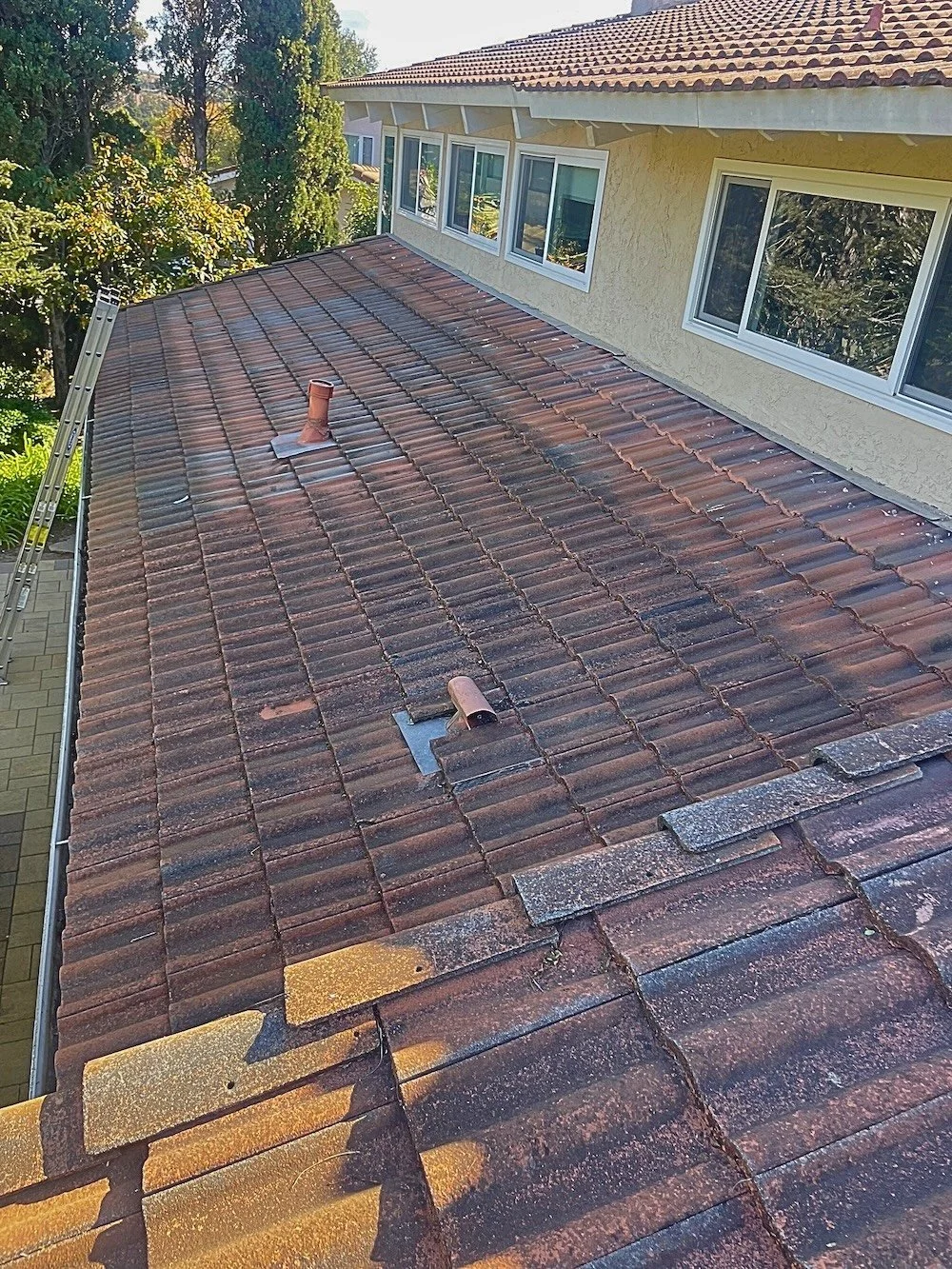 Close‑up of a old asphalt shingle roof with fading and granule loss before replacement on a Santa Barbara home.