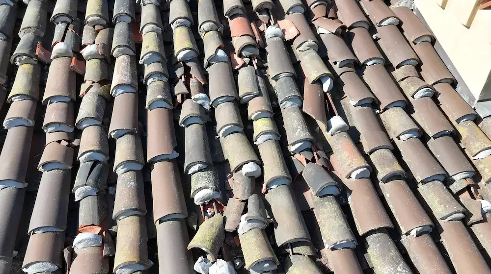 Close-up of damaged and slipped mission clay tiles on a Santa Barbara Riviera home requiring professional roof maintenance.