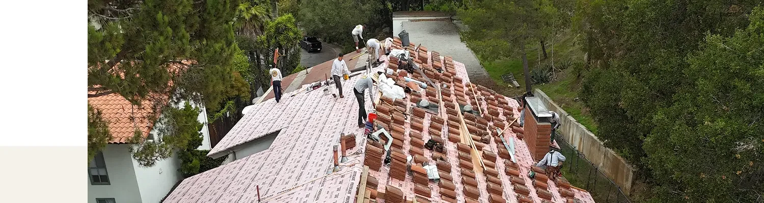Quality Roofing crew installing clay tiles over waterproof underlayment in Santa Barbara.