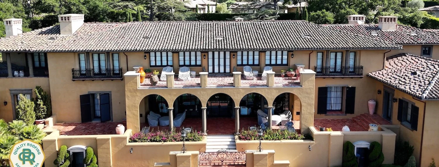 Drone view of a luxury Santa Barbara estate with an architectural clay tile roof and detailed balconies.