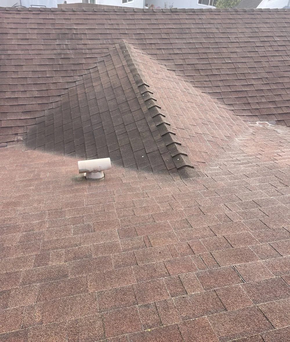 Worn asphalt shingle hip and ridge with discoloration and aging shingles on a Santa Barbara roof before replacement.