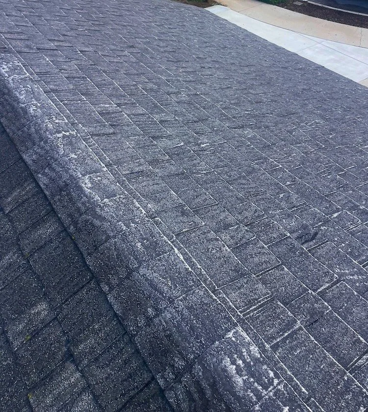 Close‑up of a worn asphalt shingle roof with visible granule loss before replacement on a Santa Barbara home.