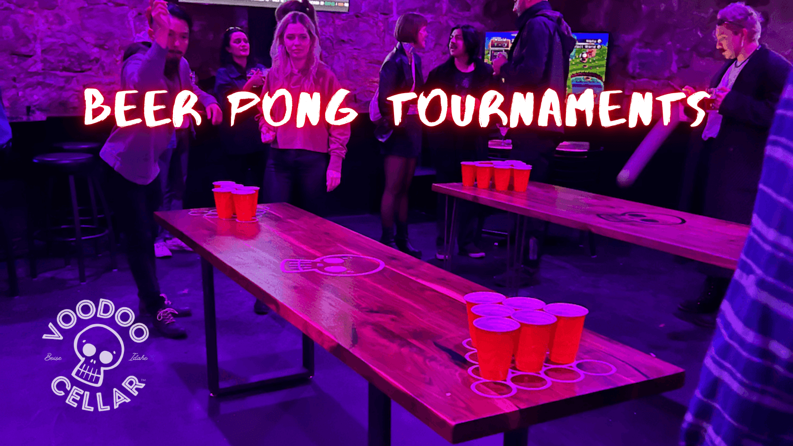 Banner showing BEER PONG TOURNAMENTS heading with people playing at the three beer pong tables inside Voodoo Cellar Boise