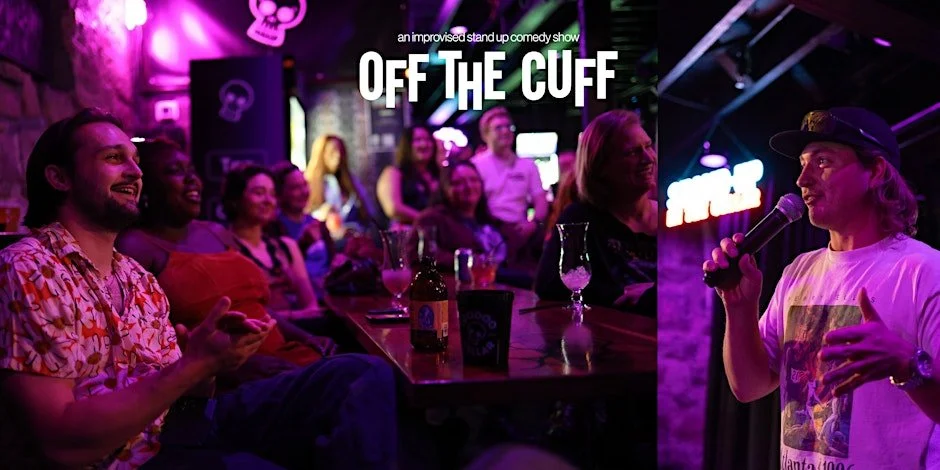 Audience members sitting at tables in a dimly lit comedy club, watching a stand-up comedian perform on stage with a microphone, colorful neon lights.